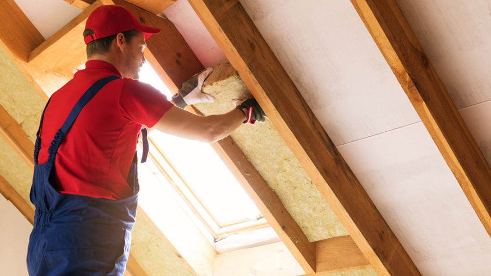 A technician insulating the attic