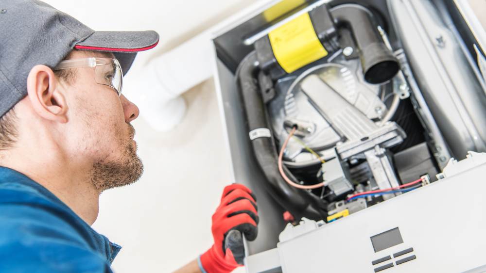 HVAC technician fixing furnace