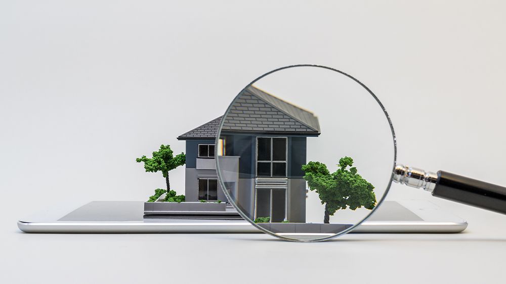 Miniature house model with a magnifying glass