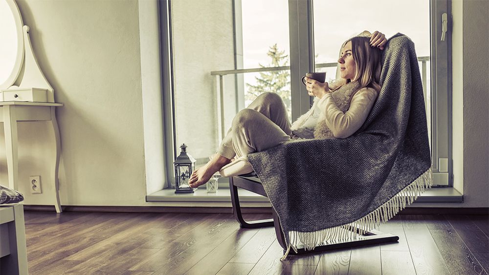 Woman relaxing with coffee in a comfy rocking chair