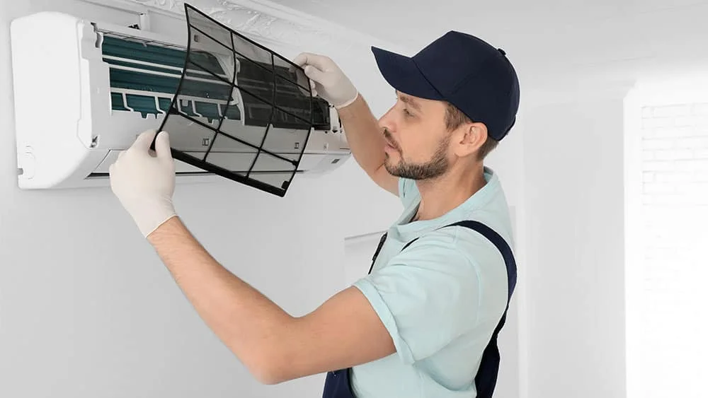 An HVAC professional checking air filters