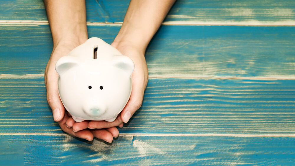 energy saving tip use less appliances. person holding piggy bank.