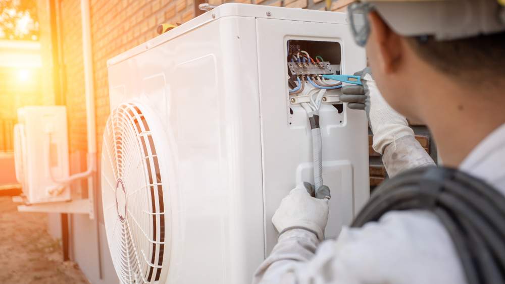 professional inspecting outdoor unit of heat pump
