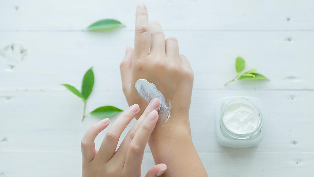 A woman applying moisturizer on her hands