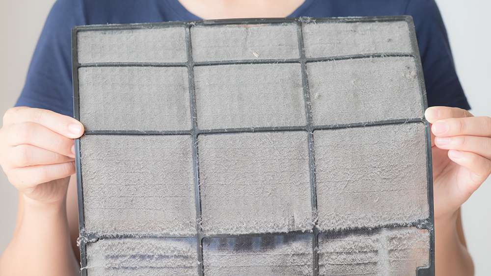 A man holding dirty air filters