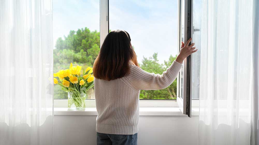 girl opening window for ventilation