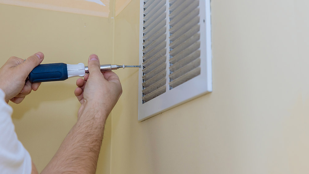 A man fixing air vent