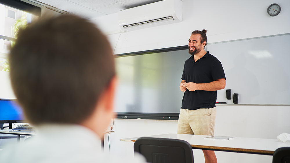 Mini-split air conditioner installed in a school. A teacher is giving lecture in a comfortable classroom