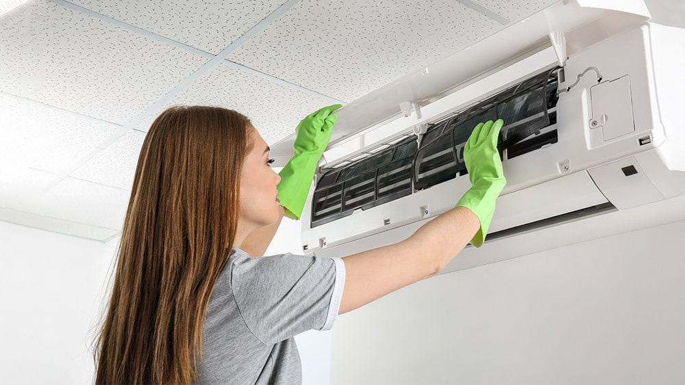 A girl cleaning air conditioner.
