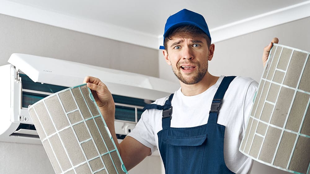Technician holding dirty AC air filters.