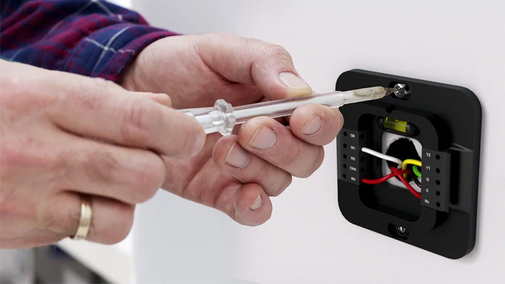 man installing cielo smart thermostat on the wall