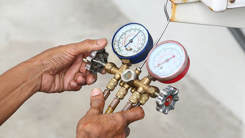 HVAC technician checking refrigerant levels
