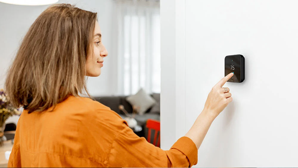 A person adjusting temperature on cielo smart thermostat
