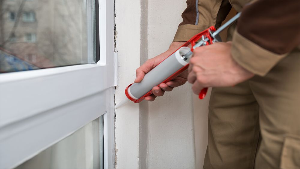 A man caulking the sides of the door
