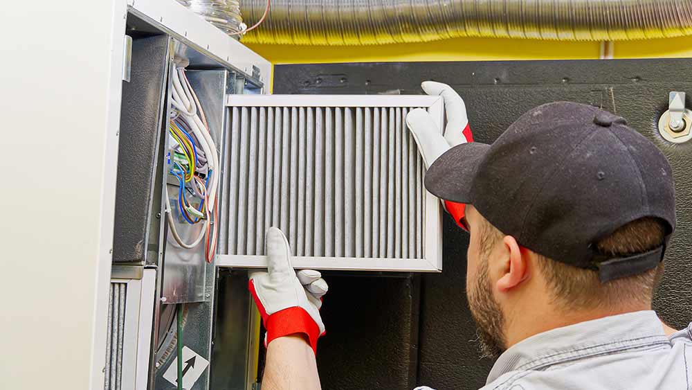 A person replacing furnace filters