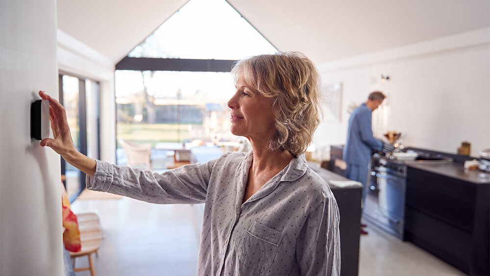 woman changing thermostat settings